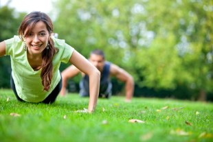 Fit people doing push-ups at the park